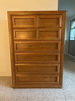 Front view showing all six drawers with inset panel design on wood.
