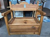 Front view of pine wood bench showing seat, storage compartment, armrests, and scalloped backrest.