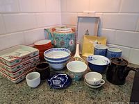 Overview of complete set including tea pot, plates, cups, bowls, and spoon rest