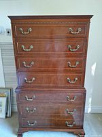 Full frontal view of the solid wood bedroom dresser showcasing six drawers and brass handles in a warm brown finish.