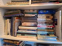 Bookshelves filled with 29 books about ships, ocean liners, Titanic, and steam ships in very good condition.