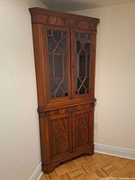 Full view of corner cabinet showing overall structure, wood finish, and door configuration