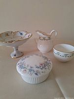 Four fine china items shown: Wedgwood covered dish, PM East German footed dish, Hammersly & Co cream and sugar set.