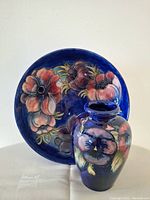 Front view of bowl and vase showing floral design