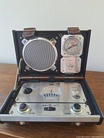 Front view of the radio opened showing speaker, clock, buzzer switch, control panel with tuning dial and knobs.