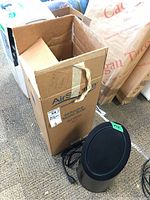 Photo showing the AirSource Model 3000 air purifier standing beside its original tall cardboard box with visible branding and model number.