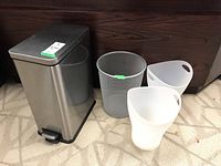 Photo showing entire lot with 4 bins: a large silver metal pedal bin, one gray mesh metal bin, and two white plastic Umbra bins.