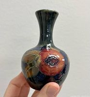 Front view showing the hand-painted pomegranate on a dark blue background with leaves and berries.