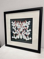 Framed folk art oil painting on rice paper showing multiple white chickens with red combs clustered together, matted and in a black frame.