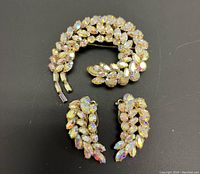 Three-piece Sherman jewelry set on black background showing brooch and earrings adorned with aurora borealis rhinestones.