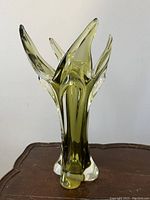 Front view of olive green flame-form glass vase showing upward flared protrusions
