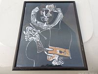 Framed print of Picasso style cubist "Portrait of a Painter" with wood frame and dark background.