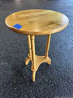 Front view of the 16-inch round side table showing the solid wood top and turned legs with triangular base.