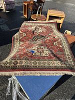 Photo showing the full carpet laid out on blue table outdoors with surrounding furniture.