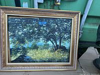 Oil painting in ornate gold and brown frame depicting trees, fence, and grass in natural setting.