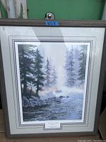 Framed painting showing a misty forest scene with a flowing river, signed Morning Mist by Elaine Carr.