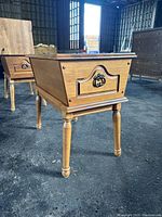 Close-up front angle showing solid wood construction, decorative drawer with metal ring pull handle, and turned legs.