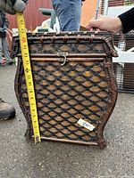 Side view of the wicker and wood box showing the height measurement marking about 17 inches tall and the curved wood base detail.
