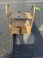 Front view of the small wicker shelf unit showing two shelves and two woven doors