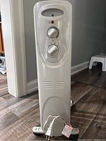 Front view showing control panel with power and heat level dials, power indicator lights, and power cord wrapped at the base.