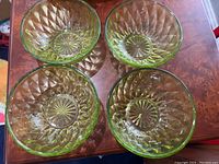Top view of four green glass bowls showing diamond pattern and starburst base design.