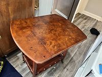 Top view showing the richly grained burl walnut drop-leaf top in expanded position.