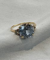Front view of ring showing cushion cut blue topaz and band