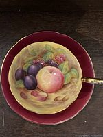 Top-down view of teacup interior showing fruit motif and gilt rim