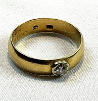 Angled view of ring showing bezel set diamond and interior surface