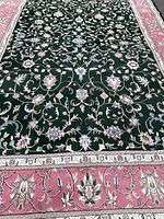 Close-up of dark green field with floral vine motifs in beige, light blue, and dusty rose.