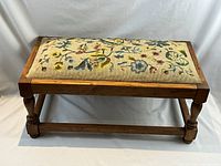 Front view of oak stool with needlepoint seat