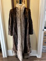 Full frontal view of brown mink coat with light fur trim, showing full length