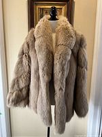 Front view of tan/beige fur coat on mannequin