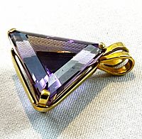 Front view of triangular faceted amethyst in 14K gold prong setting