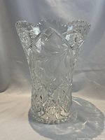 Full front view of crystal vase showing floral cut glass patterns and scalloped rim.