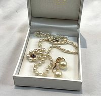 Necklace and earrings displayed inside original white presentation box