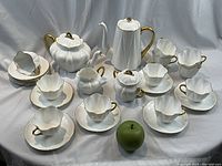 Overview of full tea and coffee set with green apple for scale