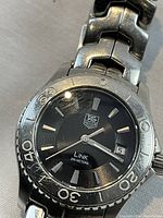 Close-up of black dial, bezel and date window at 3:00