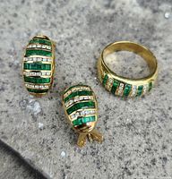 Pair of gold earrings and ring on stone surface