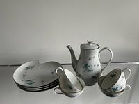 Full tea set including teapot, four cups, and four side plates.