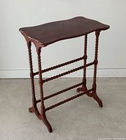 Full view of antique table showing flame mahogany veneer top with scalloped edges, spindle twisted legs, crossbars and overall structure.