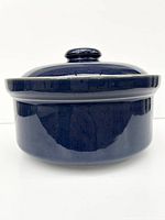 Side profile of dark blue glazed casserole dish with lid, showing glossy finish and stoneware texture.