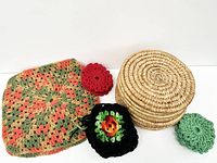 View of assorted handmade vintage coasters and one large crocheted trivet showing various colors and patterns