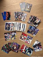 Top view of all sports cards spread on a wood surface showing several basketball and hockey cards in grouped piles