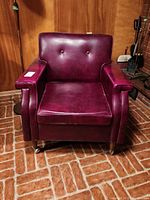 Front view showing tufted back, square seat cushion and caster wheels