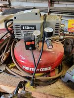 Front view showing the brand, pressure gauge, and power switch on the red cylindrical tank.