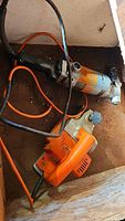 Photo showing Black and Decker electric hand planer and electric metal nibbler tools on a dusty wooden surface.