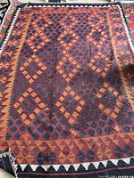 Full view of rug laid flat, showing overall geometric pattern and color scheme