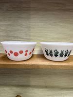 Two milk glass bowls side by side, one with red polka dots and one with black rooster design