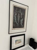 Two framed prints on white wall showing relative size and framing